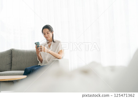 一個女人坐在沙發上和放鬆 125471362