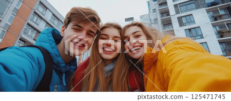 Smiling Friends Taking a Selfie Outdoors in Urban Setting 125471745