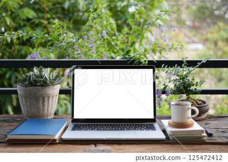Laptop and notebooks with coffee cup, urban balcony outdoor workspace 125472412