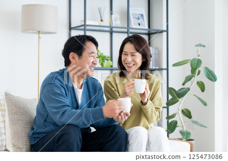 Middle-aged couple drinking coffee in the living room 125473086