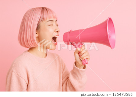 日本年輕女子在粉紅色的世界裡用擴音器大喊 125473595