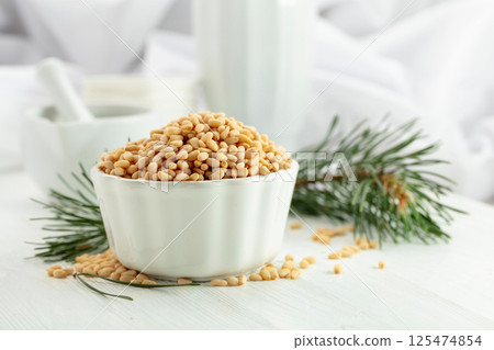 Peeled pine nuts on a white wooden table. 125474854
