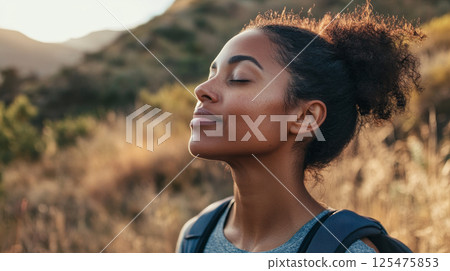 Peaceful Woman Enjoying Sunlight in Nature 125475853