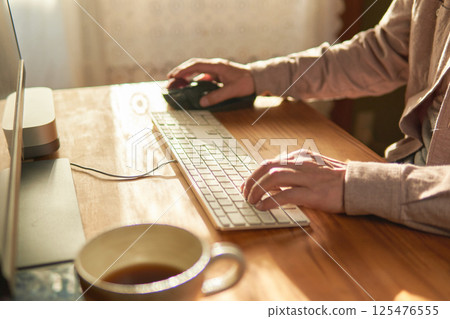 A man working on a computer at home. 125476555