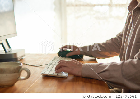 A man working on a computer at home. A man working on a computer at home. 125476561