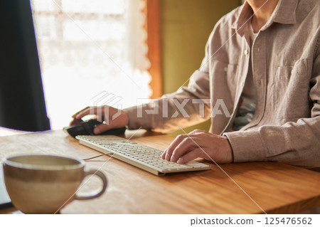 A man working on a computer at home. 125476562