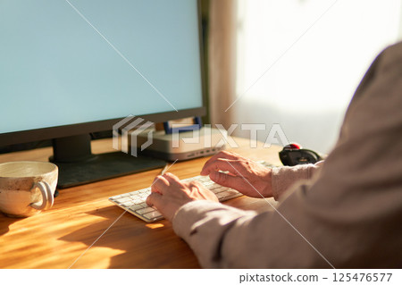 A man working on a computer at home 125476577