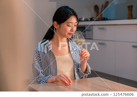 一位獨居女子在家享用葡萄酒 一位獨居女子在家享用葡萄酒 125476606