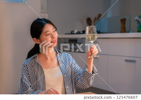 一位獨居女子在家享用葡萄酒 一位獨居女子在家享用葡萄酒 125476607