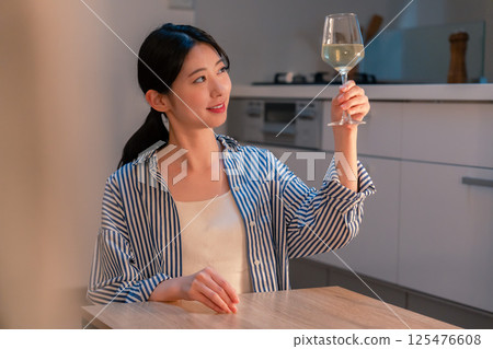 A woman living alone enjoying wine at home A woman living alone enjoying wine at home 125476608