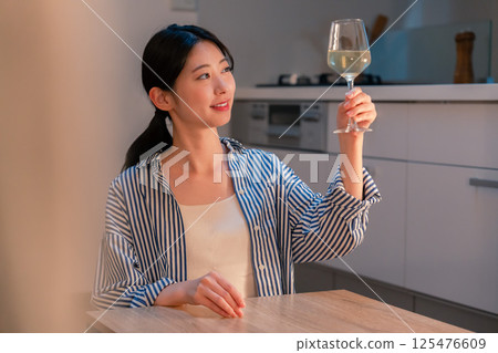 一位獨居女子在家享用葡萄酒 一位獨居女子在家享用葡萄酒 125476609