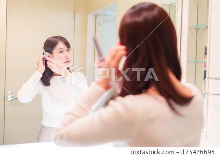 A middle-aged woman getting ready before going out 125476695