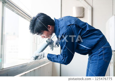 男工人在外部施工過程中塗抹填縫材料 125476775