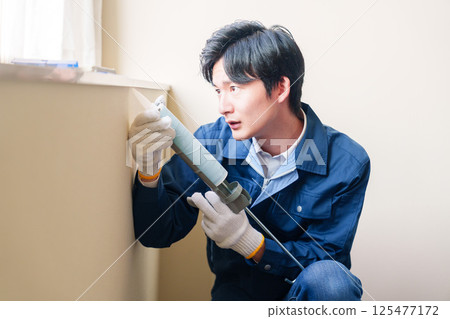 男工人正在為窗戶填縫 125477172