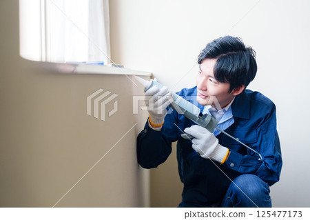 男工人正在為窗戶填縫 男工人正在為窗戶填縫 125477173