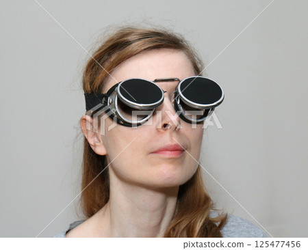 Young woman with black welding glasses Young woman with black welding glasses 125477456