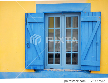 Blue wooden window on a yellow wall Blue wooden window on a yellow wall 125477564
