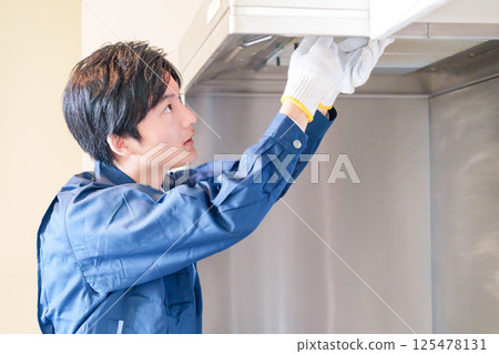 Male worker cleaning the range hood 125478131