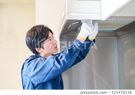 Male worker cleaning the range hood 125478136