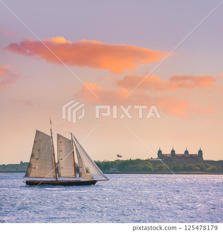 New York sailboat sunset and Ellis Island 125478179