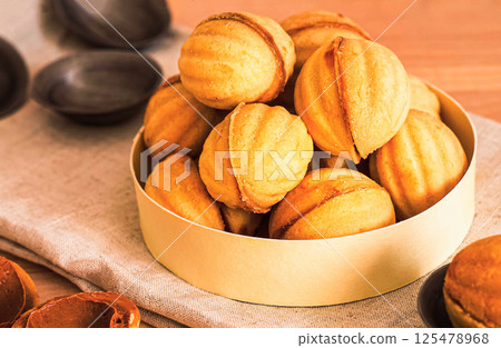 homemade cookies shaped nuts with cream boiled condensed milkt on wooden table. 125478968