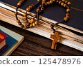 Wooden rosary beads on old books. Wooden background 125478976