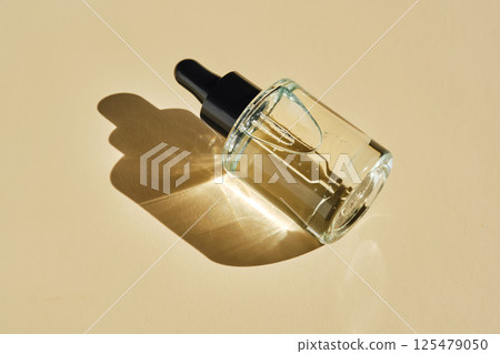 Oil essence for the face on a beige background. Oil essence for the face on a beige background. 125479050
