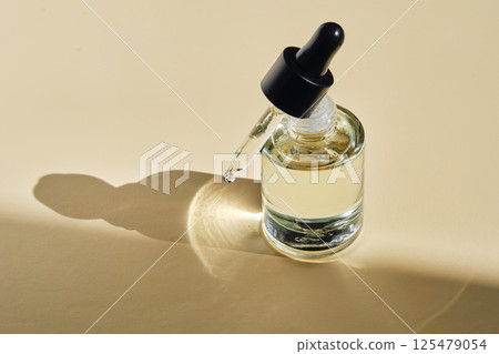 Oil essence for the face on a beige background. Oil essence for the face on a beige background. 125479054