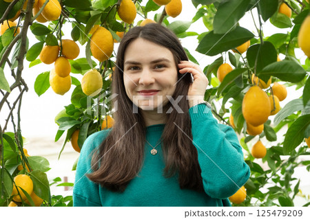 Woman in lemon orchard smiling and looking at camera 125479209
