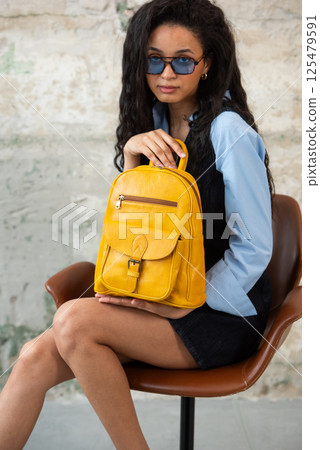 A Chic Outfit Featuring a Bright Yellow Backpack Paired with Stylish Sunglasses and Trendy Dress and Blue Shirt 125479591