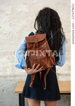 A Chic Outfit Featuring a Bright Brown Backpack Paired with Stylish and Trendy Dress and Blue Shirt 125479652