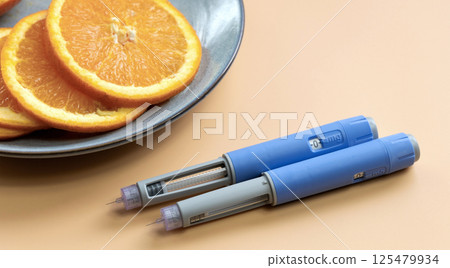 Two Insulin injection pen for diabetics and weight loss and plate with orange Two Insulin injection pen for diabetics and weight loss and plate with orange 125479934