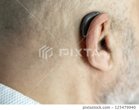 Male head from back with hearing aid on ear 125479940