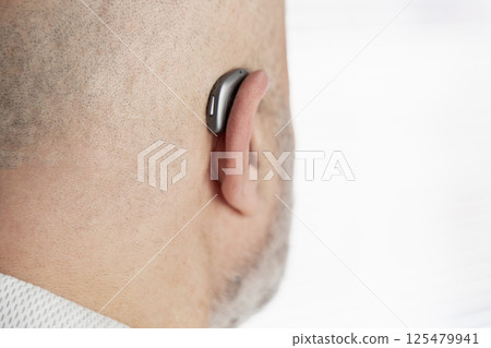 Male head from back with hearing aid on ear 125479941