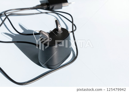 Modern hearing aid in the charginng dock 125479942