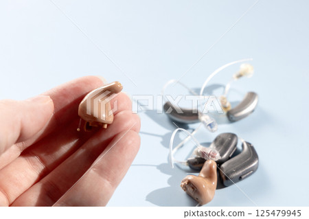 Female hand holding modern hearing aid 125479945