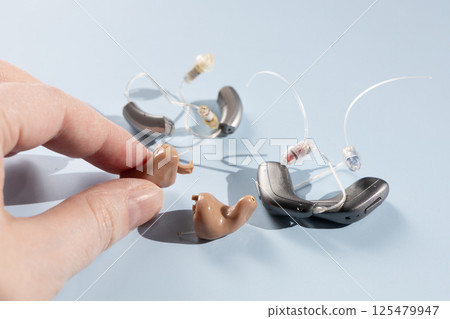 Female hand holding modern hearing aid 125479947