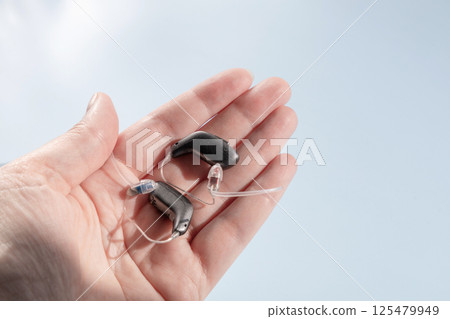 Female hand holding modern hearing aid 125479949