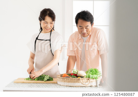 A couple in their 50s cooking in the kitchen 125480087