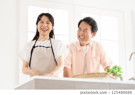 A couple in their 50s cooking in the kitchen 125480089