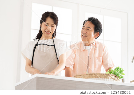 A couple in their 50s cooking in the kitchen 125480091