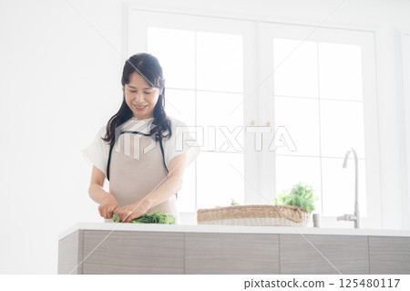 A housewife in her 50s cooking 125480117