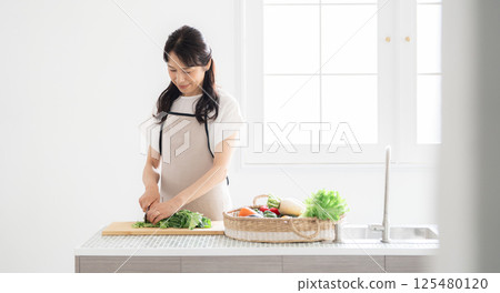 A housewife in her 50s cooking 125480120