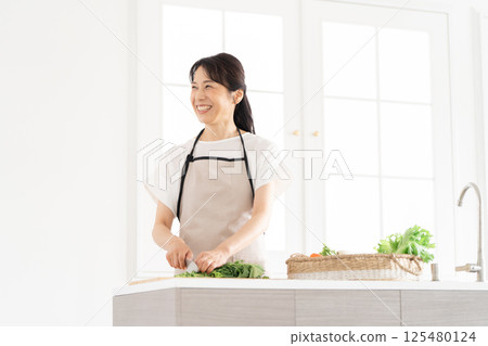 A housewife in her 50s cooking 125480124
