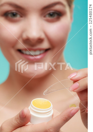 woman applying balsam for lips woman applying balsam for lips 125480174