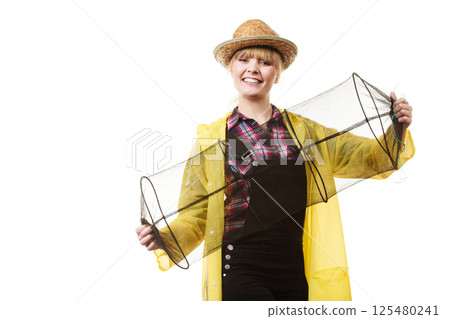 Happy woman holding empty fishing keepnet Happy woman holding empty fishing keepnet 125480241