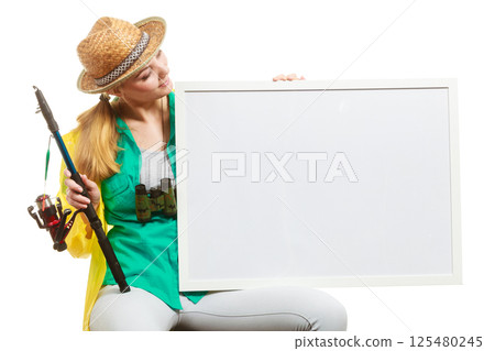 Happy woman with fishing rod holding board Happy woman with fishing rod holding board 125480245