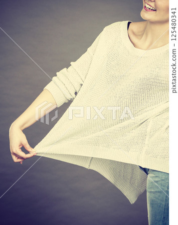 Woman wearing too big jumper 125480341