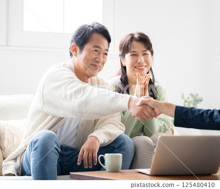 Couple in their 50s, business meeting, living room, sales visit 125480410