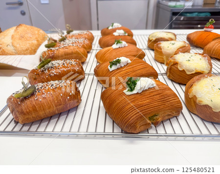 Gourmet croissants with savory toppings. Concept of modern pastry and artisan snack variety Gourmet croissants with savory toppings. Concept of modern pastry and artisan snack variety 125480521